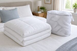 ベッドにたたんだ白い掛け布団と洗濯ネット